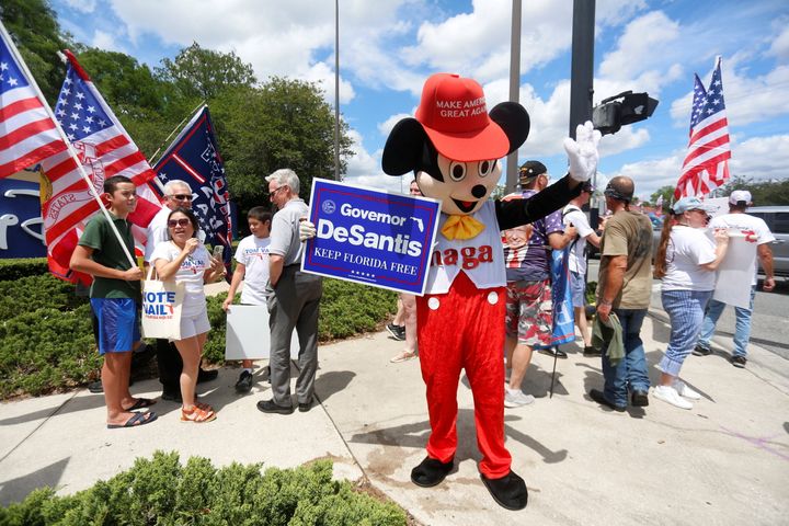 A person wearing a mouse costume holds a Gov. Ron DeSantis poster and stands with supporters of Florida's Republican-backed "Don't Say Gay" bill that bans classroom instruction on sexual orientation and gender identity for many young students on April 16.