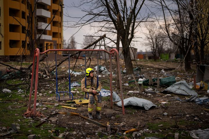 A firefighter sits on a swing next to a building destroyed by a Russian bomb in Chernihiv on April 22. 