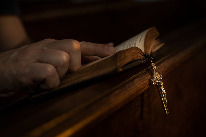 Man praying in dark church