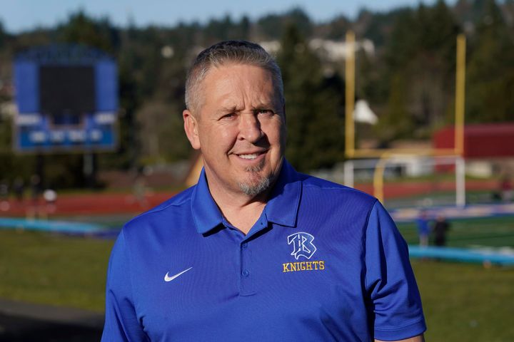Joe Kennedy, a former assistant football coach at Bremerton High School in Bremerton, Wash., poses for a photo March 9, 2022, at the school's football field. After losing his coaching job for refusing to stop kneeling in prayer with players and spectators on the field immediately after football games, Kennedy will take his arguments before the U.S. Supreme Court on Monday.