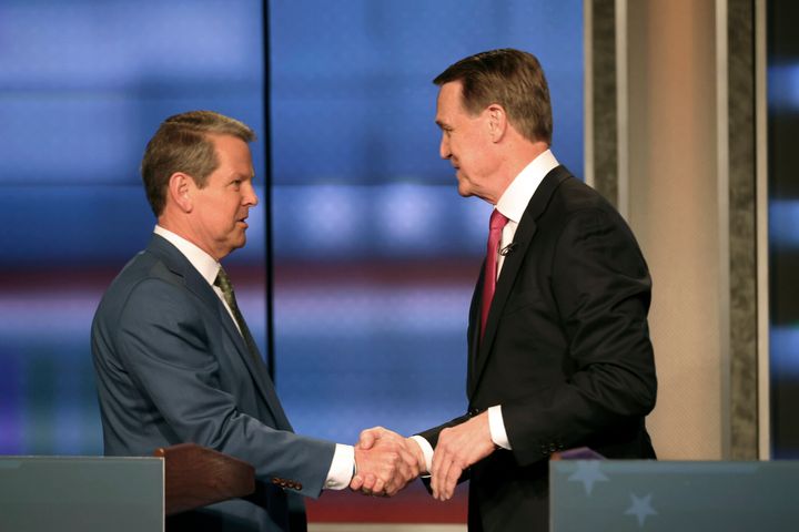 Georgia Gov. Brian Kemp, left, shakes hands with former Sen. David Perdue at a Republican gubernatorial debate on April 24, 2022, in Atlanta.