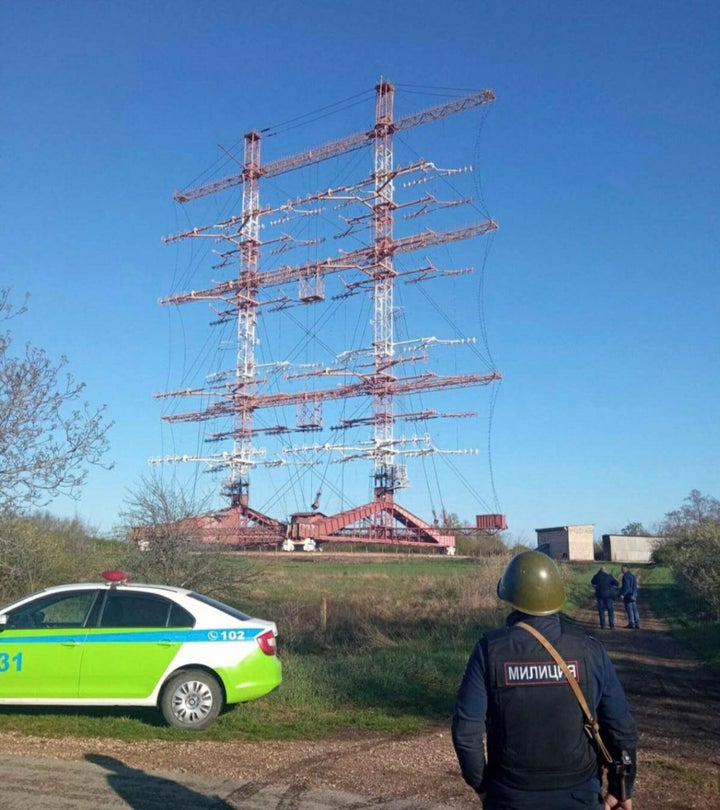 In this photograph released by the Press Center of the Ministry of Internal Affairs of the Pridnestrovian Moldavian Republic, a policeman stands by a radio station in Maiac, in the Moldovan separatist region of Trans-Dniester, Tuesday, April 26, 2022.