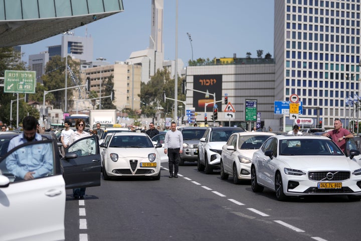 Israelis stand still next to their cars on a main road as a two-minute siren sounds in memory of victims of the Holocaust in Tel Aviv, Israel, on April 28, 2022.