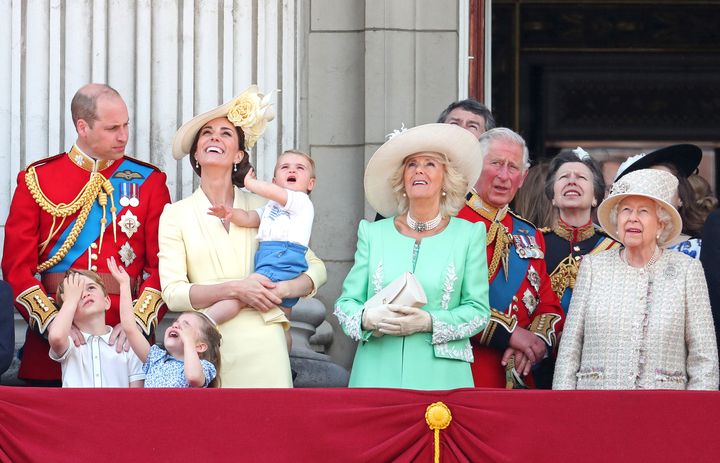 Miembros de la familia real en Trooping the Colour, el desfile anual de cumpleaños de la reina, el 8 de junio de 2019 en Londres.  Camilla, duquesa de Cornualles, vestida de verde menta, ante el príncipe Carlos.  El príncipe William y Catherine, duquesa de Cambridge, de pie a la izquierda con sus hijos George, Charlotte y el bebé Louis. 