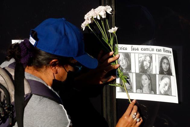 여성인권운동가들이 붙인 실종 여성들의 사진들. 한 시민이 꽃을 들고 눈물짓고