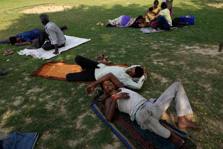 People rest in the shade of a tree on a hot summer afternoon in Lucknow in the central Indian state of Uttar Pradesh, Thursday, April 28, 2022. 