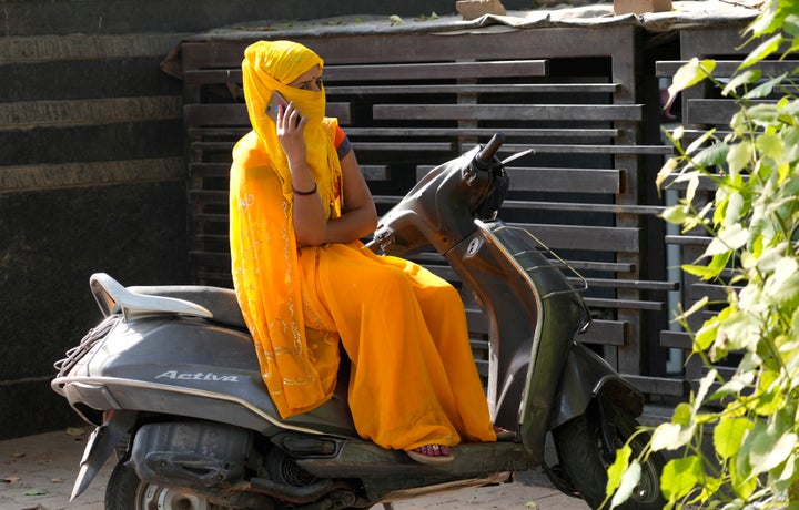 A woman sits with her face wrapped in a scarf on a hot summer day in Lucknow, in the central Indian state of Uttar Pradesh, Thursday, April 28, 2022.