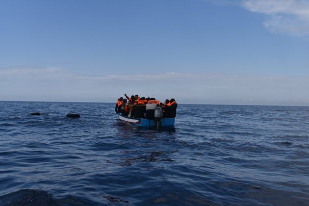 Des migrants attendent les sauveteurs de l'ONG Open Arms sur un bateau en bois, après avoir quitté...