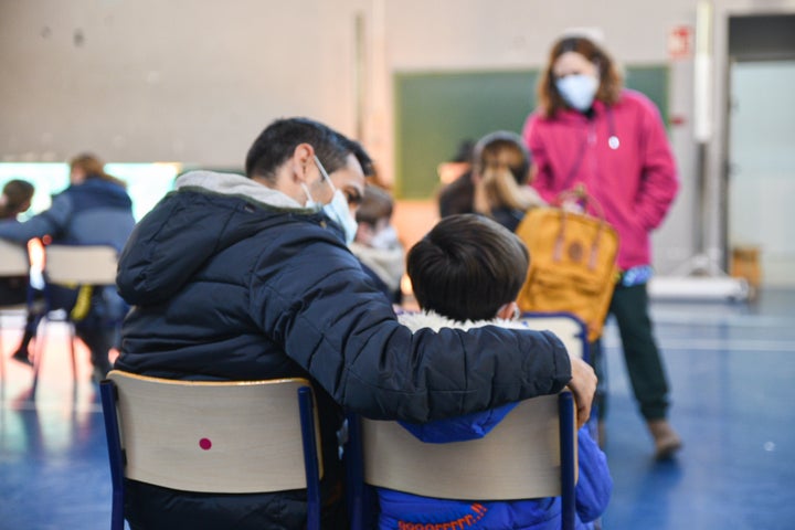 Un niño espera junto a su padre para ser atendido