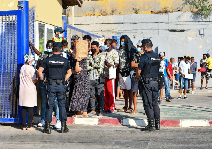 Agentes de Policía supervisan a cientos de personas en la frontera del Tarajal.