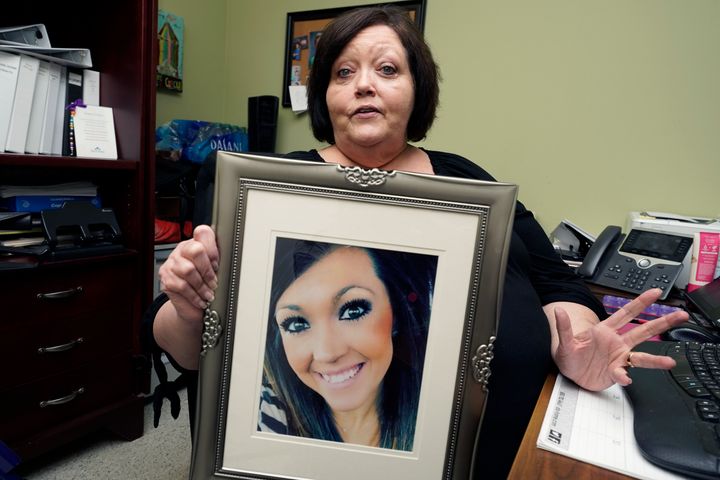 Denise Spears holds a portrait of her late step-daughter Marsha Harbour, in her Meridian, Miss., office, Tuesday, April 12, 2022. Although Marsha's husband, Truitt Pace, admitted killing his wife, he was free on bond while court proceedings were partially held up because the Mississippi Medical Examiner's Office autopsy report was delayed for a year, and the trial got held up further because of the pandemic and other factors. Harbour was a victim of domestic violence. 