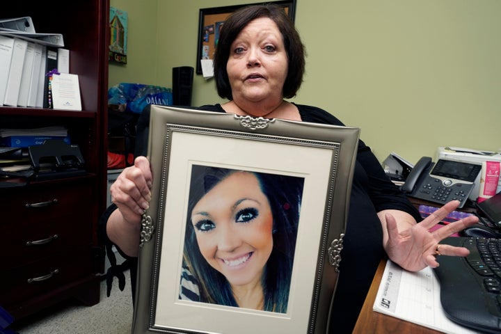 Denise Spears holds a portrait of her late step-daughter Marsha Harbour, in her Meridian, Miss., office, Tuesday, April 12, 2022. Although Marsha's husband, Truitt Pace, admitted killing his wife, he was free on bond while court proceedings were partially held up because the Mississippi Medical Examiner's Office autopsy report was delayed for a year, and the trial got held up further because of the pandemic and other factors. Harbour was a victim of domestic violence.