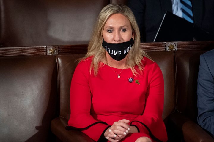 Pictured on the day of her swearing-in ceremony on Jan. 3, 2021, Marjorie Taylor Greene attempts to wear a face mask reading, “TRUMP WON.” Trump had, in fact, lost.
