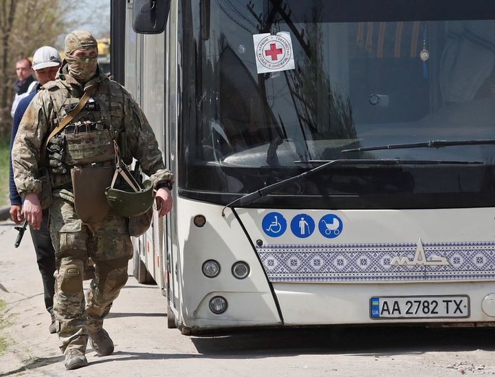 A service member of pro-Russian troops walks next to a bus parked near a temporary accommodation centre for evacuees during Ukraine-Russia conflict in the village of Bezimenne in the Donetsk Region, Ukraine May 1, 2022. REUTERS/Alexander Ermochenko