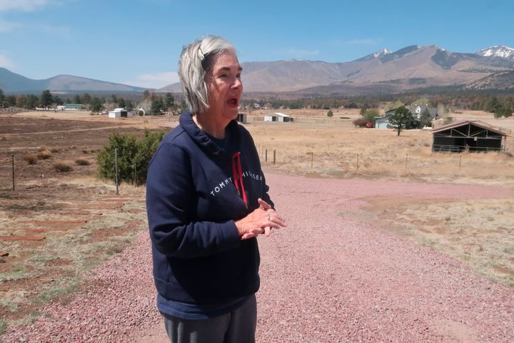 Harriet Young stands outside her home on the outskirts of Flagstaff, Ariz., Thursday, April 28, 2022. A massive wildfire that started Easter Sunday burned about 30 square miles and more than a dozen homes, hopscotching across the parched landscape.