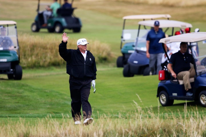 This July 14, 2018, file photo shows then-President Donald Trump waving to protesters while playing golf at his Turnberry golf club in Scotland.