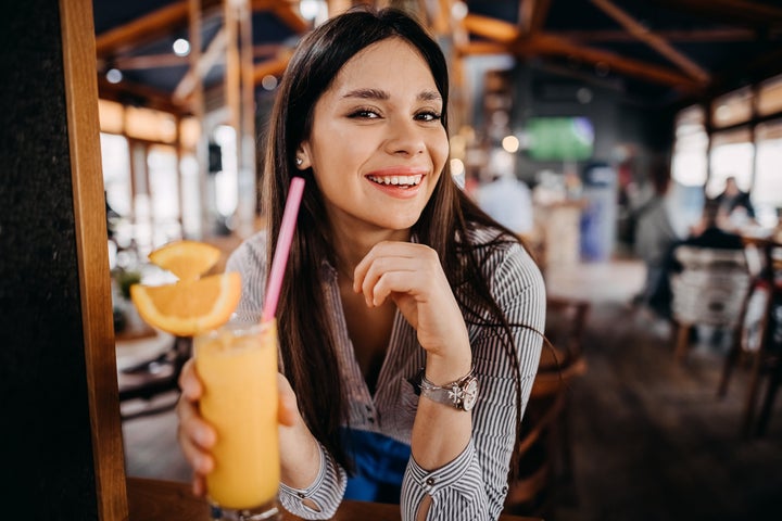 Beautiful young woman drinking orange juice