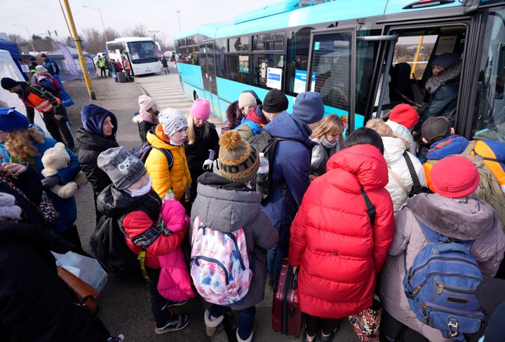People fleeing from Ukraine line up to board a bus after crossing the border in Vysne Nemecke, Slovakia, on March 3, 2022.