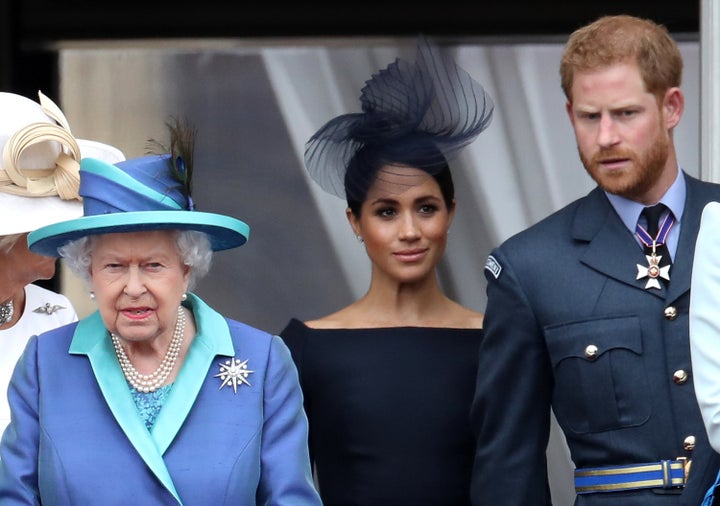 Queen Elizabeth II, Prince Harry, and Meghan, Duchess of Sussex are seen on the balcony of Buckingham Palace to mark the Centenary of the RAF on July 10, 2018, in London.