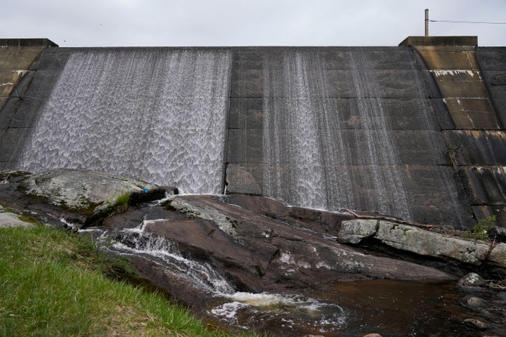 Water flows over the Lake Welch Dam in Harriman State Park near Stony Point, N.Y., Tuesday, May 3, 2022. Dozens of dams in poor condition across New York state are upstream from homes, highways or businesses, posing potential threats to people if they fail. An Associated Press analysis found 90 “high-hazard” dams in New York that also were rated in poor condition. (AP Photo/Seth Wenig)