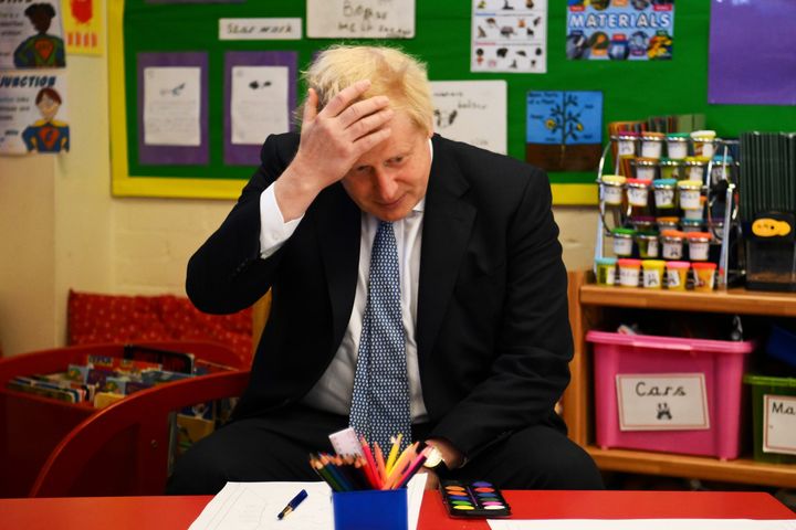 UK prime minister Boris Johnson reacts as he prepares to paint with children during a visit at the Field End Infant school on May 6, 2022.