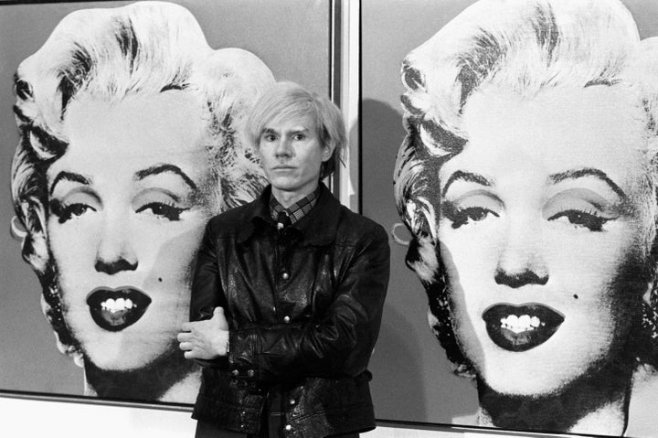 Andy Warhol stands in front of his double portrait of Marilyn Monroe at the Tate Gallery, Millbank.