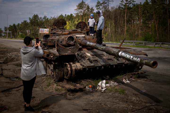 Maksym, 3, is photographed with his brother, Dmytro, 16, on top of a destroyed Russian tank, on the outskirts of Kyiv, Ukraine on Sunday, May 8, 2022. (AP Photo/Emilio Morenatti)