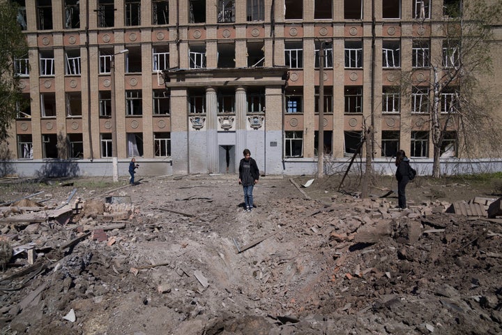 Una mujer mira el cráter de una explosión después de un ataque aéreo ruso en Kostyantynivka, región de Donetsk, Ucrania, el sábado 7 de mayo de 2022. (Foto AP/Evgeniy Maloletka)