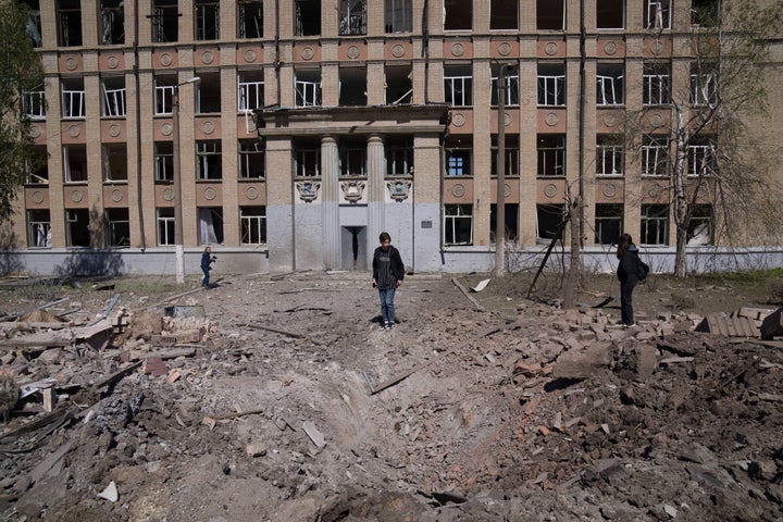 A woman looks on a crater of an explosion after Russian airstrike in Kostyantynivka, Donetsk region, Ukraine, Saturday, May 7, 2022. (AP Photo/Evgeniy Maloletka)