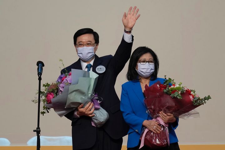 John Lee, former No. 2 official in Hong Kong and the only candidate for the city's top job, celebrates with his wife after declaring his victory in the chief executive election of Hong Kong in Hong Kong, Sunday, May 8, 2022. Lee was elected as Hong Kong's next leader Sunday by an election committee comprised of nearly 1,500 largely pro-Beijing members. (AP Photo/Kin Cheung)