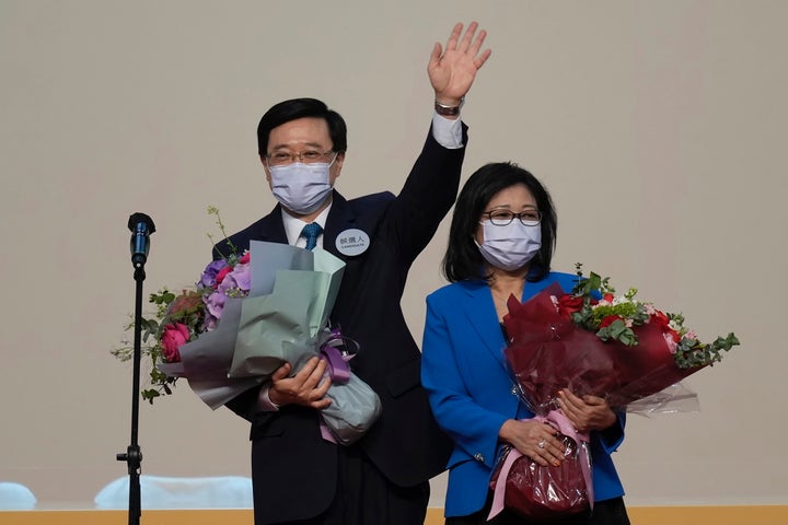 John Lee, former No. 2 official in Hong Kong and the only candidate for the city's top job, celebrates with his wife after declaring his victory in the chief executive election of Hong Kong in Hong Kong, Sunday, May 8, 2022. Lee was elected as Hong Kong's next leader Sunday by an election committee comprised of nearly 1,500 largely pro-Beijing members. (AP Photo/Kin Cheung)