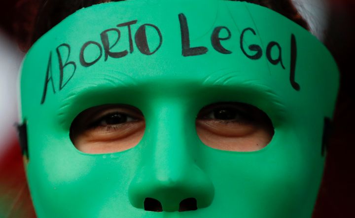 An abortion-rights activist wears a mask with text that reads in Spanish "Legal Abortion" during a rally outside Congress as lawmakers debate a bill that would legalize abortion, in Buenos Aires, Argentina, Tuesday, Dec. 29, 2020. In Argentina, lawmakers in late 2020 passed a bill legalizing abortion until the 14th week. (AP Photo/Natacha Pisarenko, File)