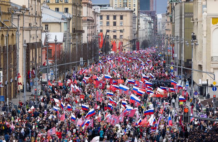 People attend the Immortal Regiment march through the main street toward Red Square marking the 77th anniversary of the end of World War II, in Moscow, Russia, on May 9, 2022. 