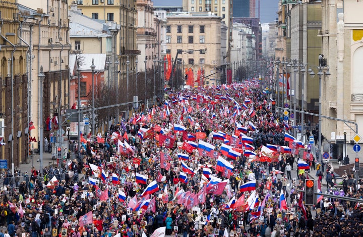 People attend the Immortal Regiment march through the main street toward Red Square marking the 77th anniversary of the end of World War II, in Moscow, Russia, on May 9, 2022.
