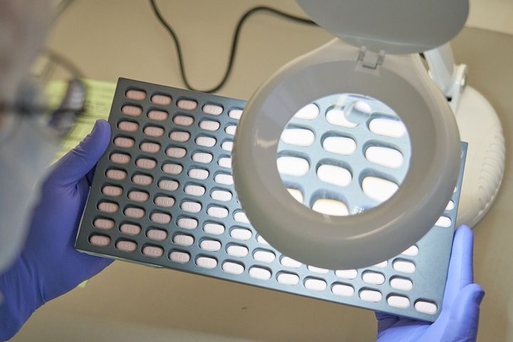 FILE - In this photo provided by Pfizer, a lab technician visually inspects COVID-19 Paxlovid tablet samples in Freiburg, Germany in December 2021. As more doctors prescribe Pfizer's powerful COVID-19 pill, new questions are emerging about its performance, including why a small number of patients appear to relapse after taking the drug. (Pfizer via AP, File)