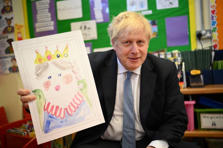Prime Minister Boris Johnson with a portrait he painted of the Queen during a school visit