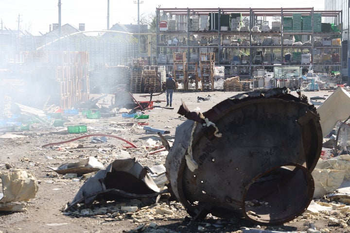 A man walks past fragments of missiles in front of the shopping and entertainment center in the Ukrainian Black Sea city of Odessa, on May 10, 2022, destroyed after Russian missiles strike late on May 9, 2022. 