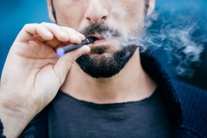 Imagen de archivo de un hombre fumando con un cigarrillo electrónico.