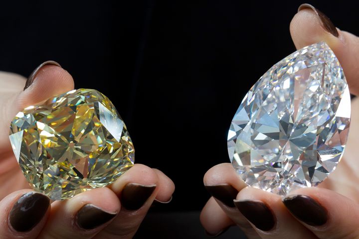 Υπάλληλος του Οίκου Christie's κρατάει τα δύο διαμάντια που πρόκειται να βγουν σε δημοπρασία, «Ο Βράχος» (δεξιά) και «Το Διαμάντι του Ερυθρού Σταυρού», την Τετάρτη, 11 Μαΐου.