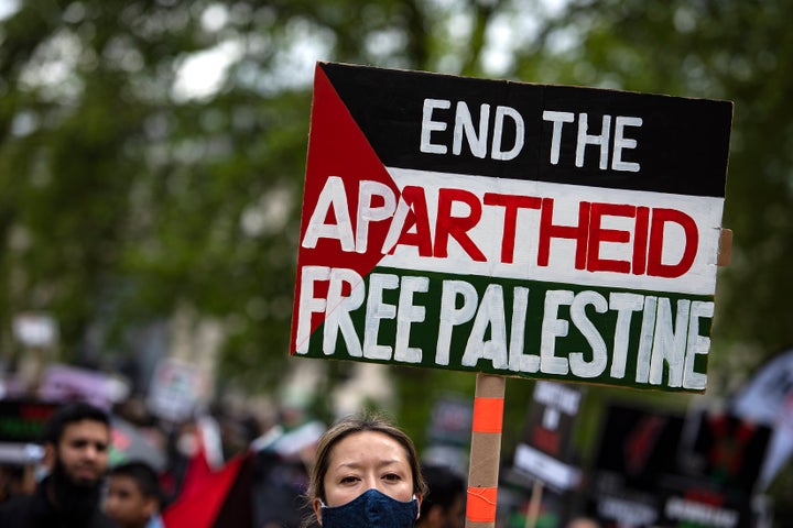 Una manifestante sostiene un cartel denunciando en "apartheid" de Israel y defendiendo la libertad de los palestinos en una marcha en Londres, el pasado 22 de abril.