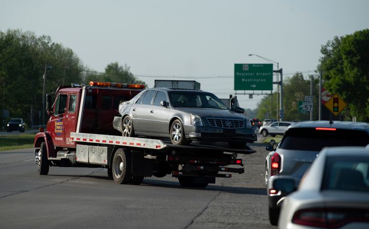 Hamrick's Towing & Recovery hauls the Cadillac sedan that fugitives Casey White and Vicky White, no relation, were driving when law enforcement officials forced them into a ditch at Burch Drive in Evansville, Ind., after a short chase Monday, May 9, 2022. (Denny Simmons/Evansville Courier & Press via AP)