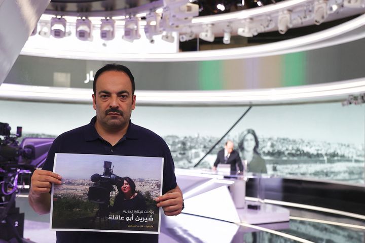 Al Jazeera journalist Haitham Abu Saleh stands holding a sign mourning the death of his network colleague Shireen Abu Aqleh (Akleh), who was killed earlier while covering an Israeli army raid on Jenin refugee camp in the occupied West Bank, at the Qatari news broadcaster's main headquarters in the capital Doha on May 11, 2022. The Qatar-based TV channel said Israeli forces shot Abu Aqleh deliberately and "in cold blood."