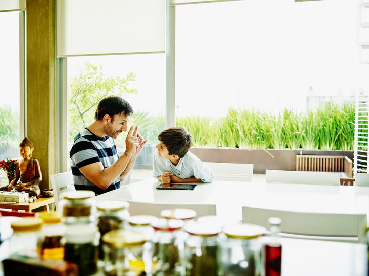 Padre e hijo hablando en la cocina.