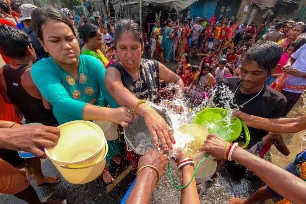 Personas llenando recipientes con agua en Kolkata, India, el 16 de abril.