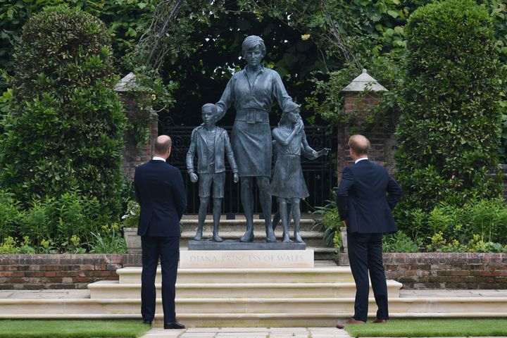 The Duke of Cambridge and the Duke of Sussex look at a statue they commissioned of their mother in the Sunken Garden at London's Kensington Palace on July 1, 2021.