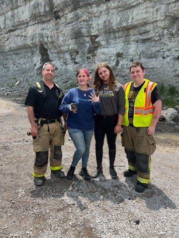 Myers Hart and his high school sweetheart, Brooklynn Stevens, with firefighters from Williamson Fire Rescue.