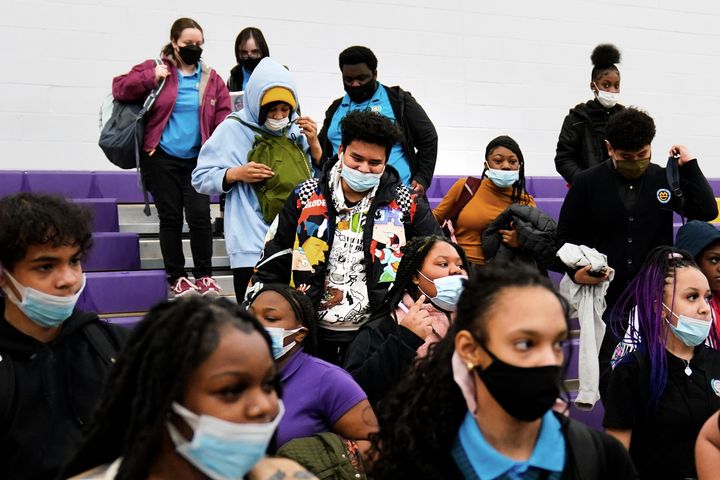Students wearing mask as a precaution against the spread of the coronavirus line up to receive KN95 protective masks at Camden High School in Camden, N.J., Feb. 9, 2022. 