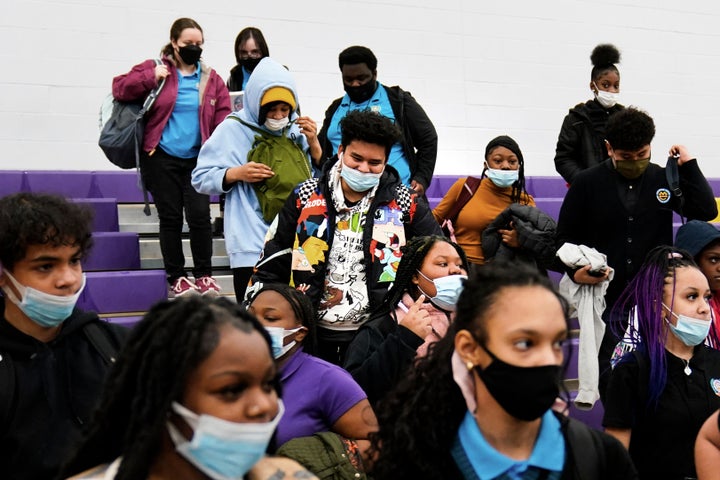 Students wearing mask as a precaution against the spread of the coronavirus line up to receive KN95 protective masks at Camden High School in Camden, N.J., Feb. 9, 2022.