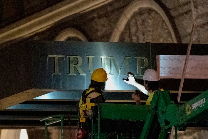 Workers remove the signage for the Trump International Hotel on May 11, 2022, in Washington. The lease to the Washington, D.C., hotel run by Donald Trump's family company while he was president, has been sold by his family company to a Miami-based investor fund.
