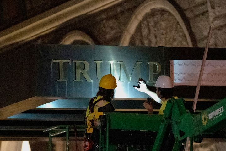 Workers remove the signage for the Trump International Hotel on May 11, 2022, in Washington. The lease to the Washington, D.C., hotel run by Donald Trump's family company while he was president, has been sold by his family company to a Miami-based investor fund. 